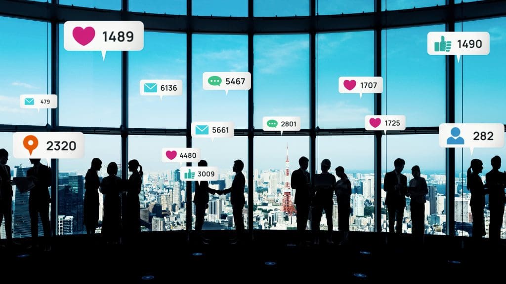 A group of people standing in front of a window with social media icons.